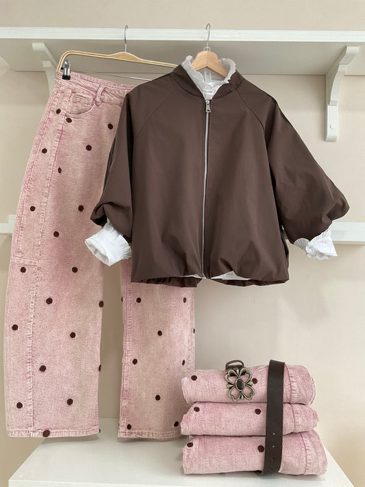 Cazadora bomber marrón con rayas laterales y pantalón rosa de pana con topos