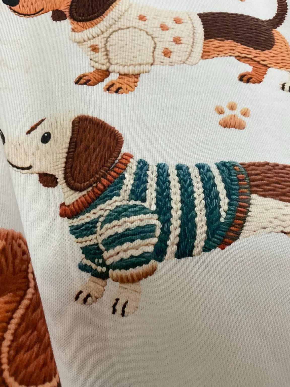 Crema — Sudadera con tres perritos — detalle del dibujo