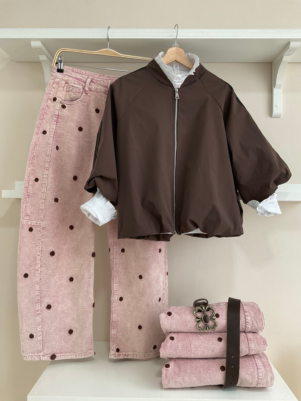 Cazadora bomber marrón con rayas laterales y pantalón rosa de pana con topos