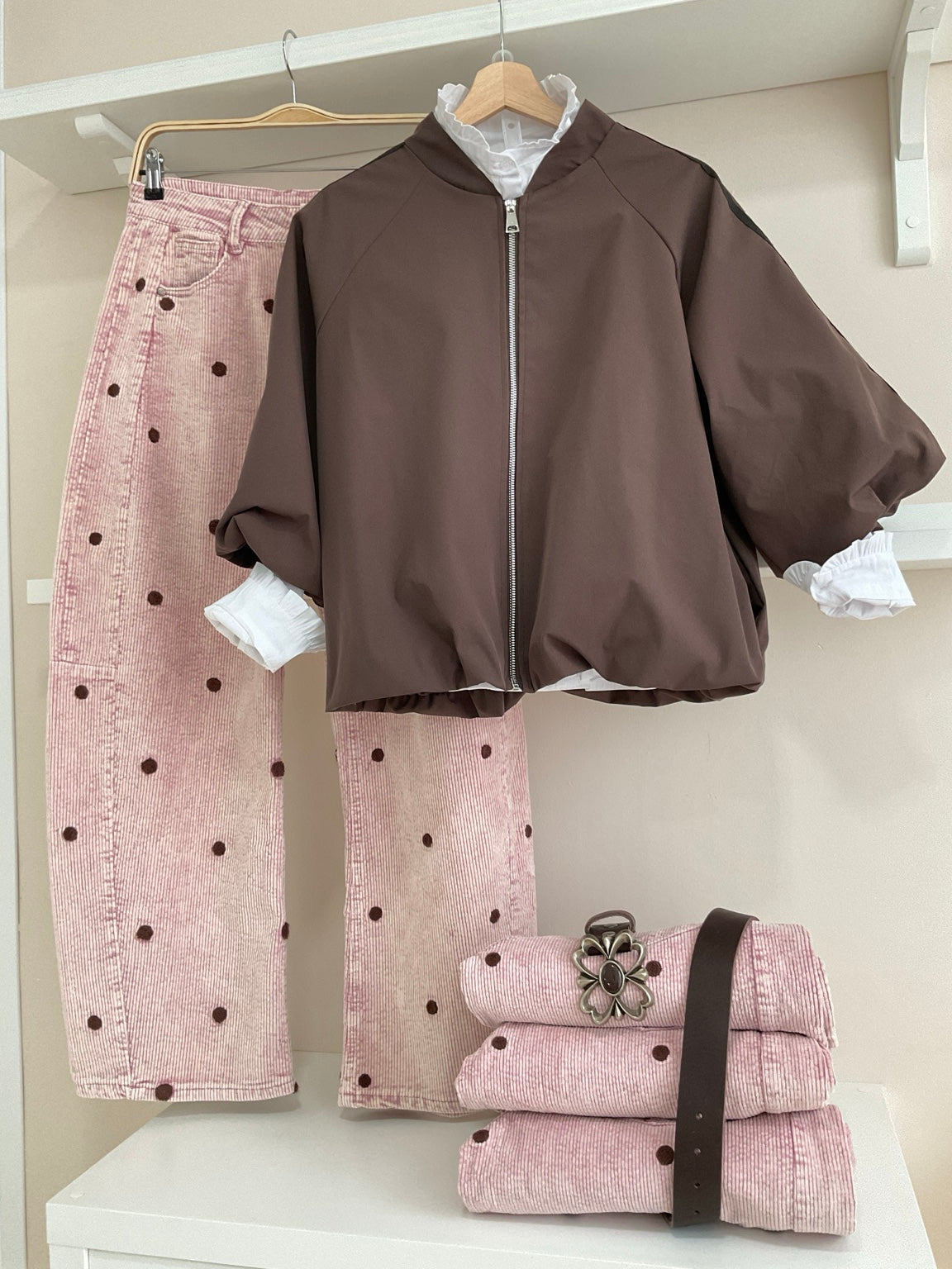 Cazadora bomber marrón con rayas laterales y pantalón rosa de pana con topos