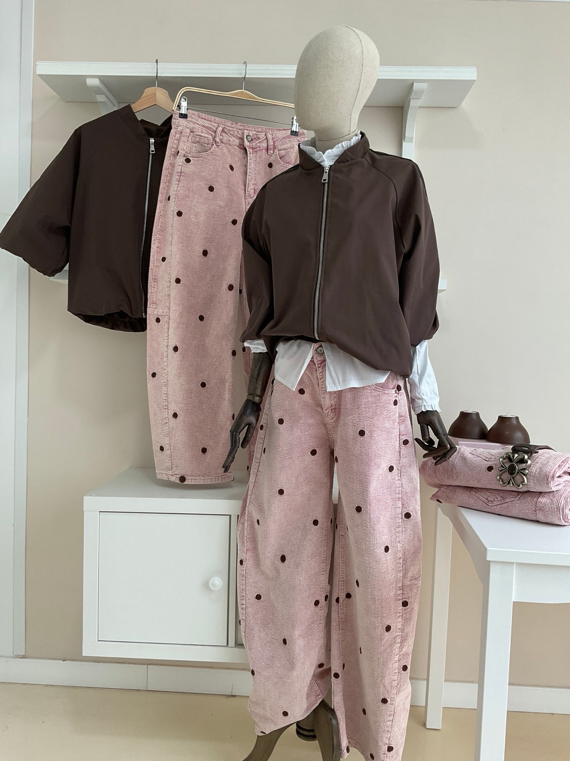 Cazadora bomber marrón con rayas laterales y pantalón rosa de pana con topos