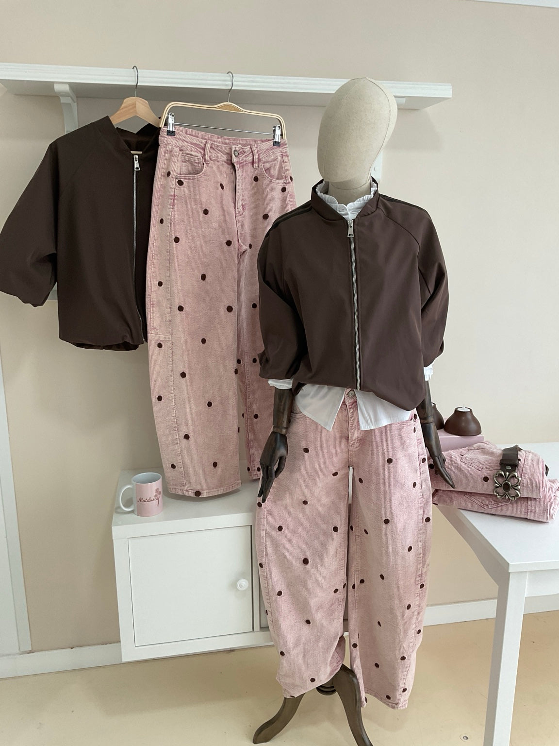 Cazadora bomber marrón con rayas laterales y pantalón rosa de pana con topos