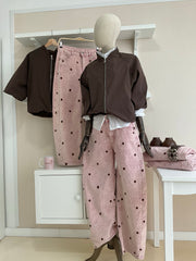 Cazadora bomber marrón con rayas laterales y pantalón rosa de pana con topos