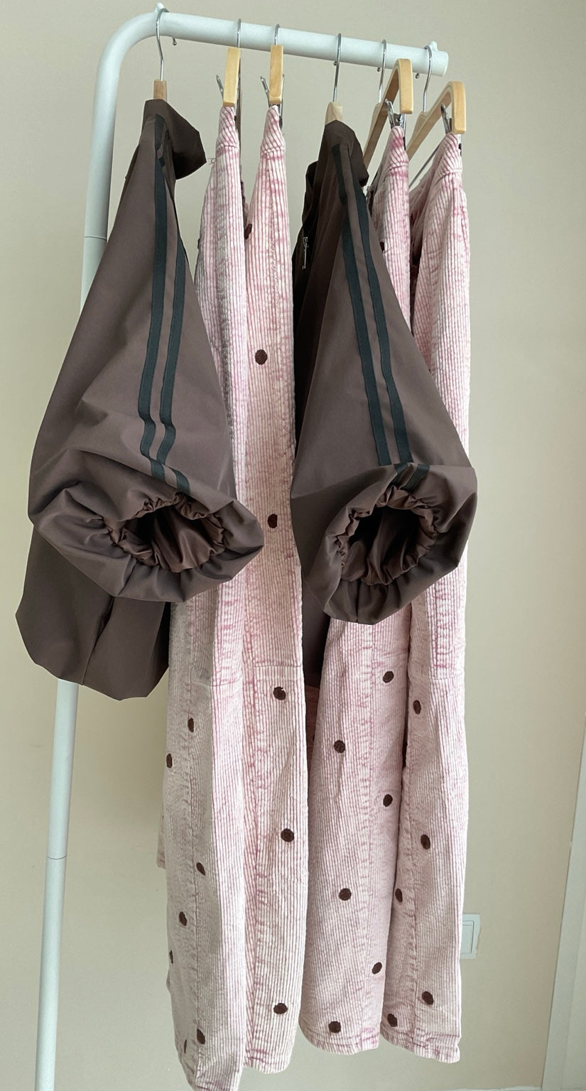 Cazadora bomber marrón con rayas laterales y pantalón rosa de pana con topos