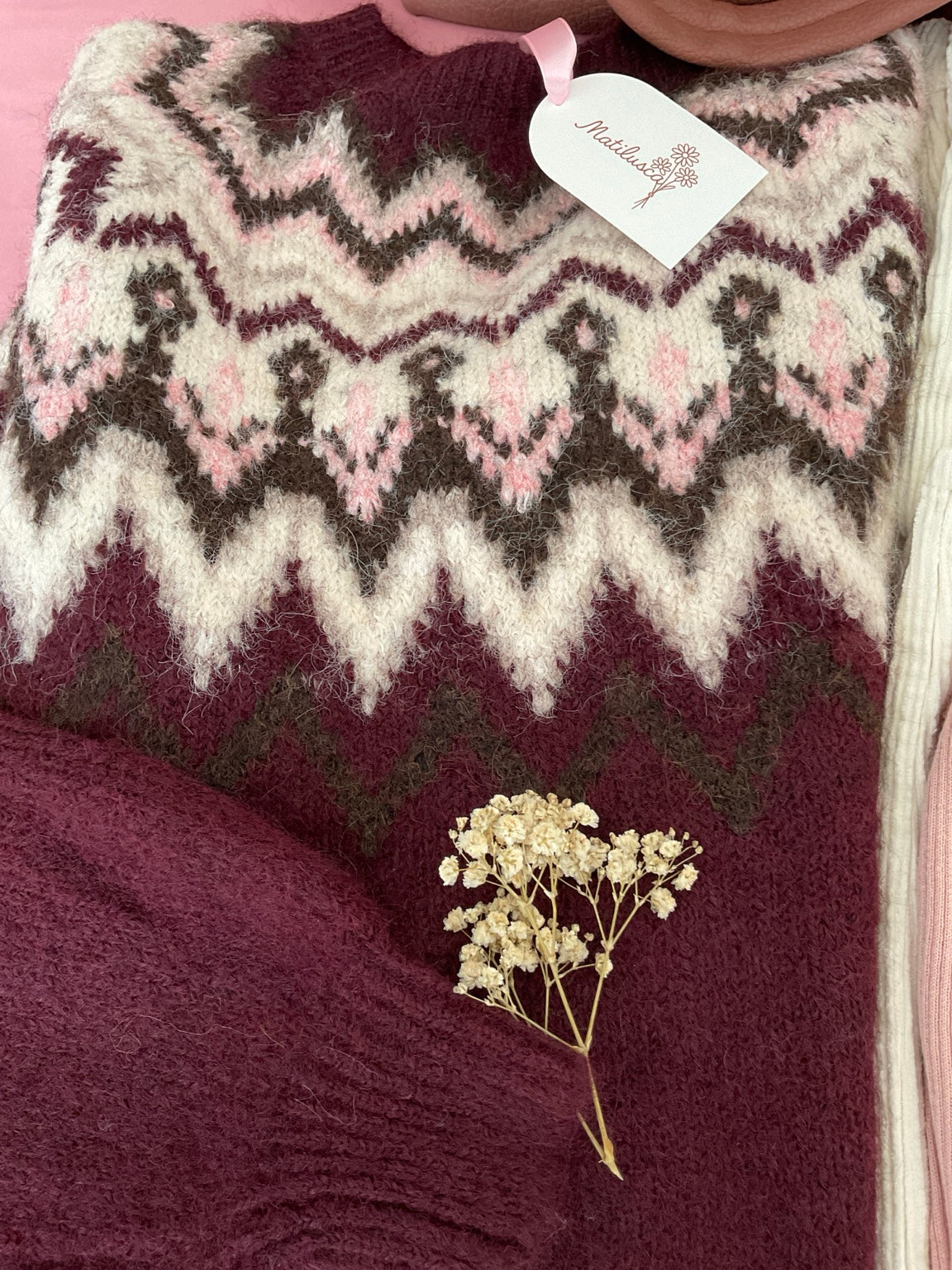 Detalle del punto y cenefas del jersey burdeos