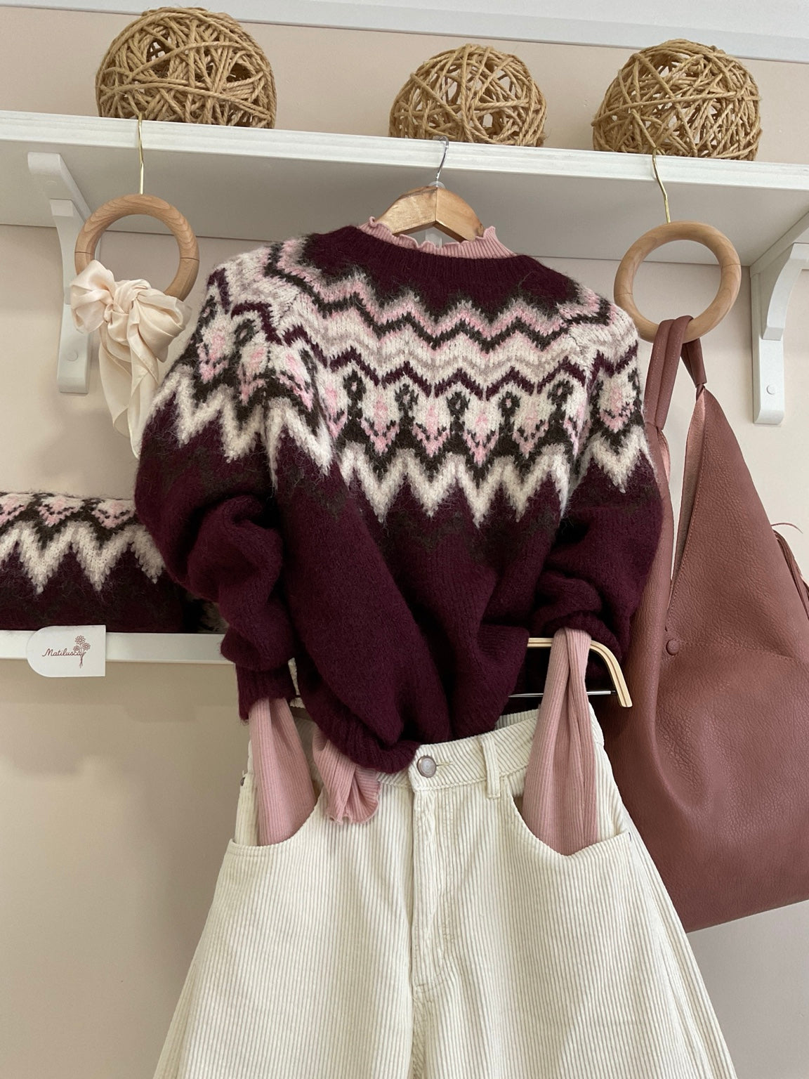 Detalle del jersey de cenefas burdeos con pana crema
