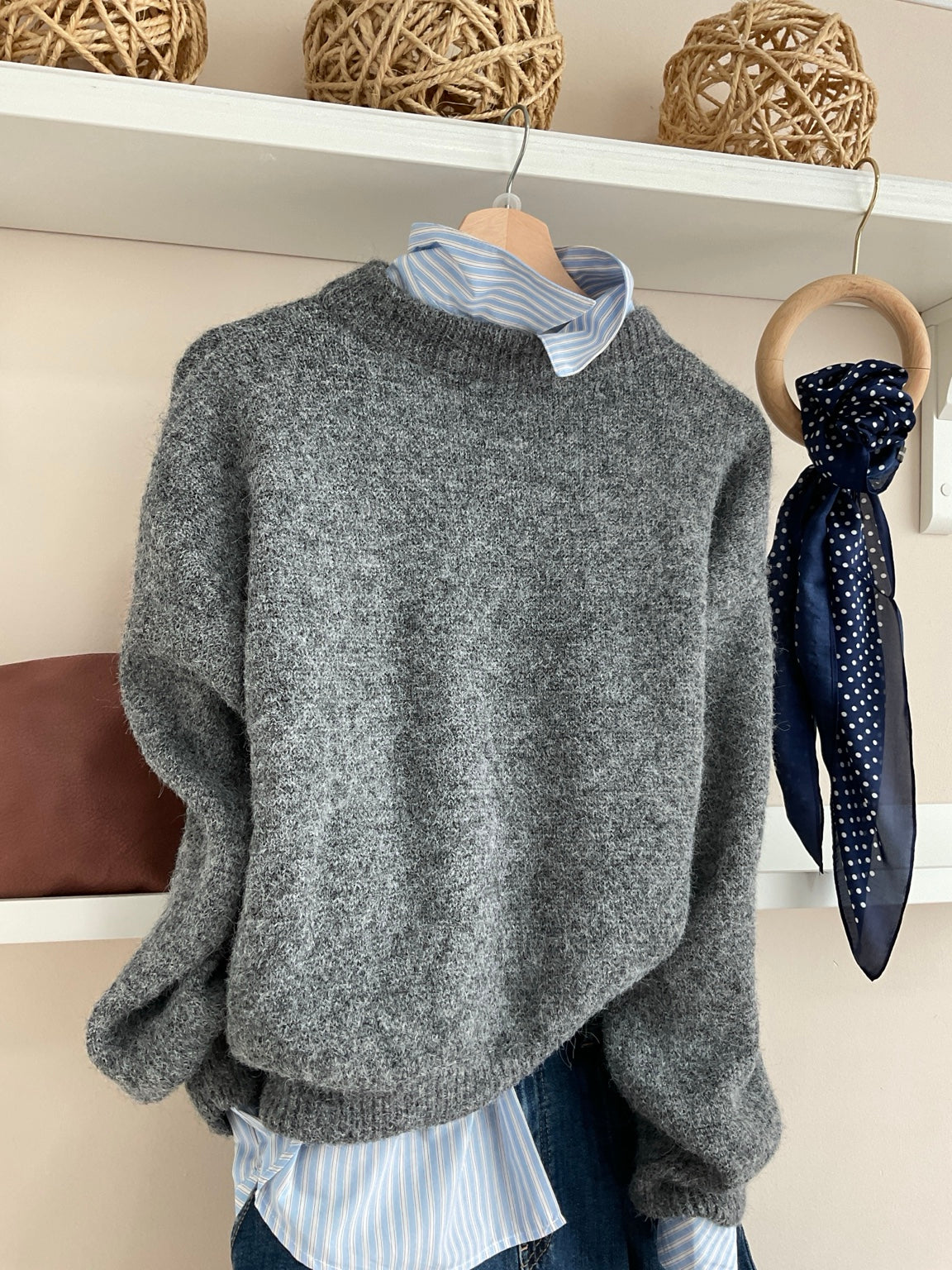 Jersey Laura gris con camisa azul y vaqueros