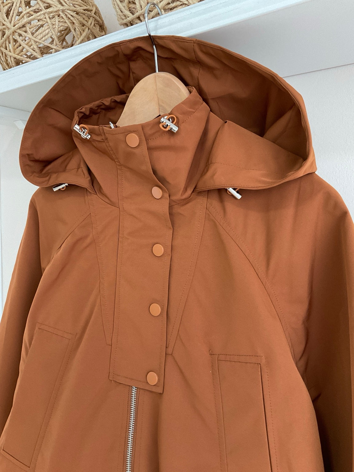 Detalle de capucha, cuello alto y botones de gabardina Stocolm