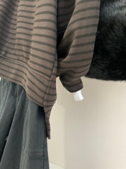 Detalle del bajo asimétrico de la sudadera de rayas chocolate y negro
