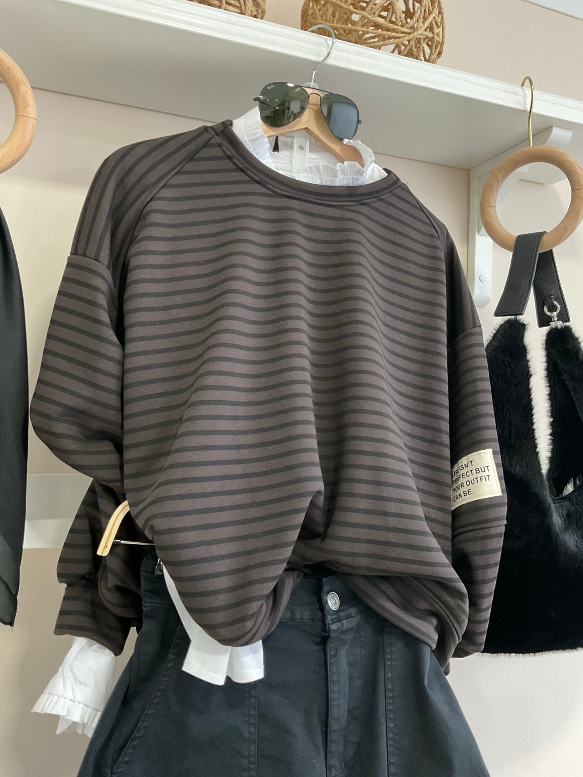 Detalle de sudadera oversize de rayas chocolate y negro