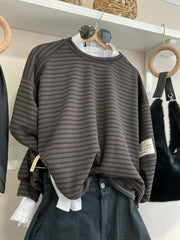 Detalle de sudadera oversize de rayas chocolate y negro