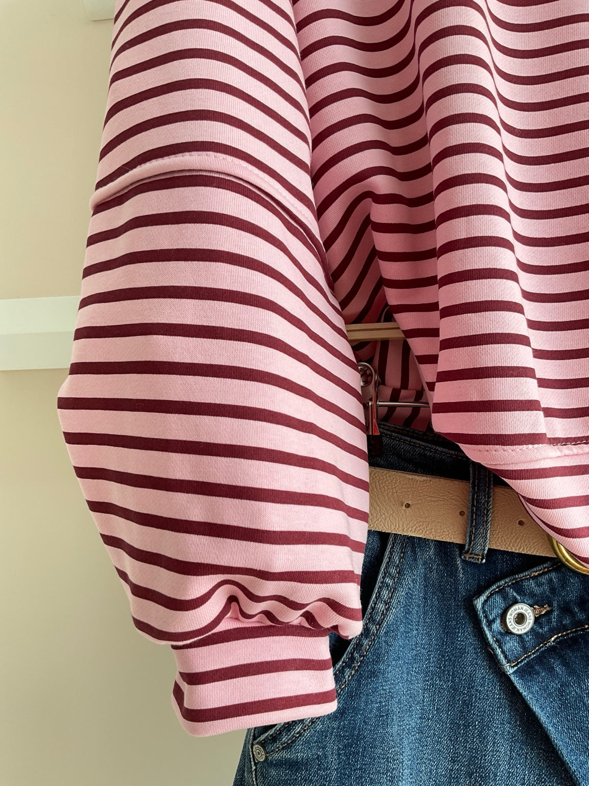 Detalle de manga de la sudadera oversize de rayas rosa y burdeos